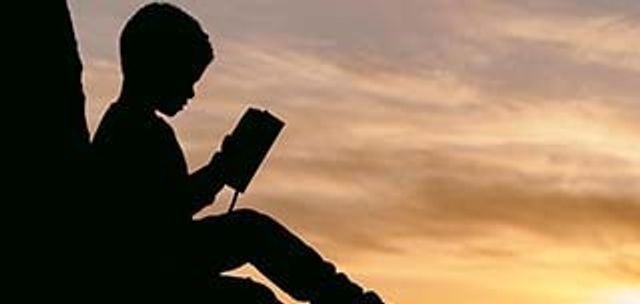 shadow image of student alone reading a book